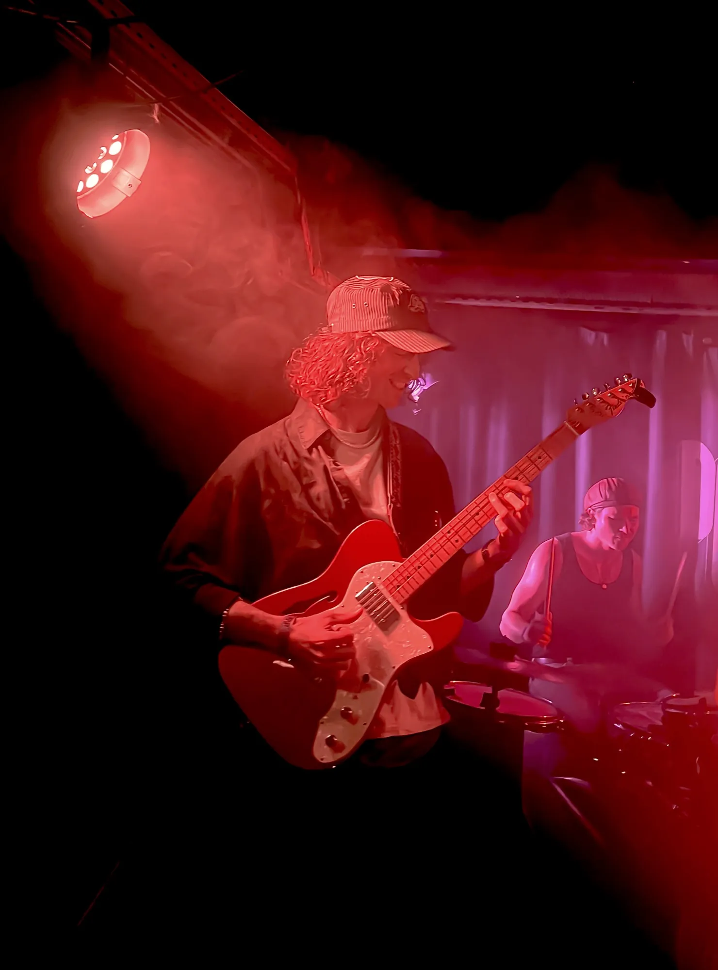 Guitariste sur scène en ambiance rouge